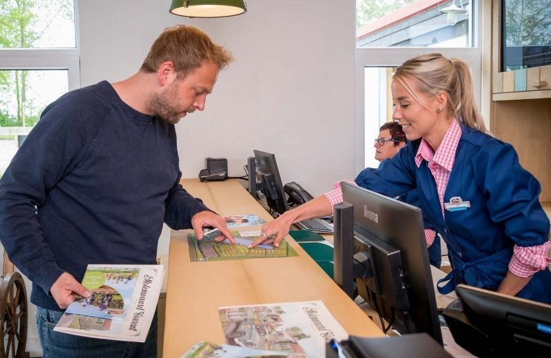 Gasten helpen bij de receptie familie resort molenwaard